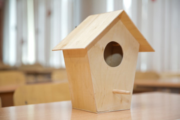 Obraz na płótnie Canvas Wooden birdhouse . Little bird house hanging amidst branches . Wooden bird's nest .