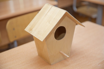 Obraz na płótnie Canvas Wooden birdhouse . Little bird house hanging amidst branches . Wooden bird's nest .