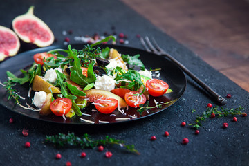 salad on a plate: arugula, cherry tomatoes, white figs, grated cheese, black grapes, avocado