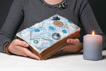 Magic book in a sorcerer hands close up.