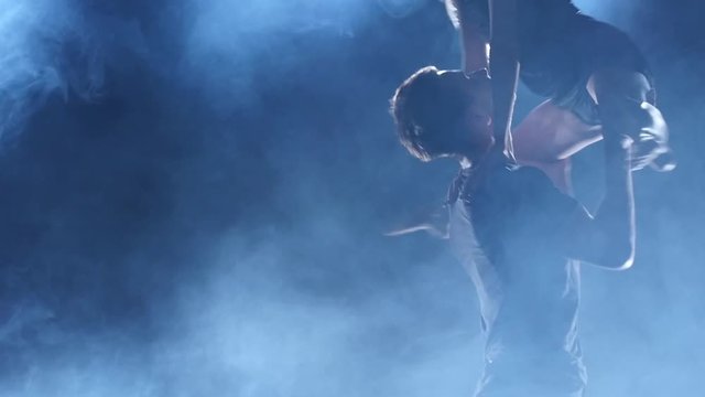 Dancers in love cling to each other at sexy contemp dance, slow motion. Close up