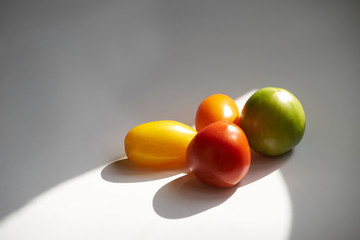 Heap of multicolored tomatoes on white background