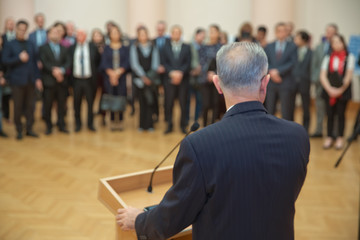 Speaker giving a talk on corporate Business Conference. Audience at the conference hall. event...