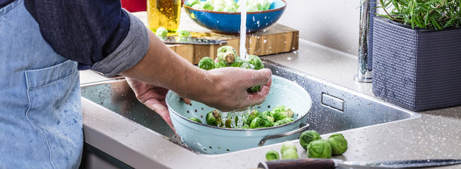 washing raw Brussels sprouts in kitchen sink