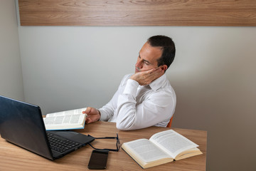 43 year old man sleeping after studying in his books and notebook.