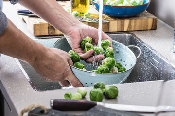 washing raw Brussels sprouts in kitchen sink
