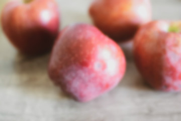red apples on wooden table blurred background