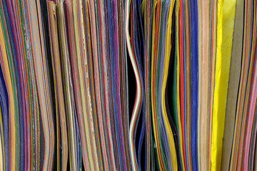 A Packed Shelf of Colored Construction Paper