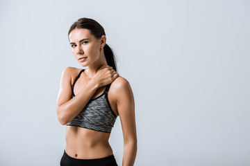 Fototapeta premium attractive sportswoman with neck pain isolated on grey