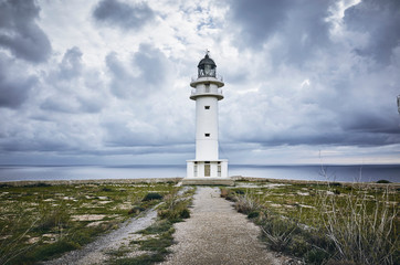 Fototapeta na wymiar Barbaria Lighthouse in formentera Islan in spain with a cloudy sky before an storm