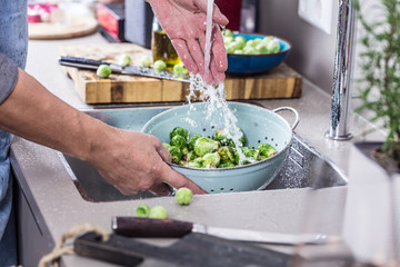 washing raw Brussels sprouts in kitchen sink