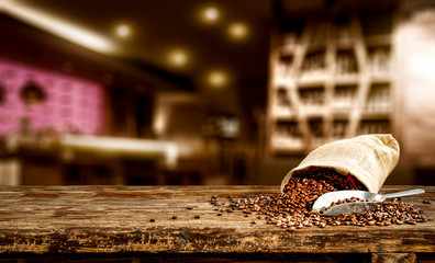 Fresh brown coffee on wooden board with free space for your decoration. Cafe interior and blurred space 