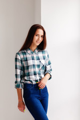 Girl in plaid shirt and jeans is on white background