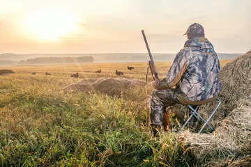 Foto op Plexiglas anti-reflex Hunter in camouflage with a gun hunting on black grouse. © Sergey