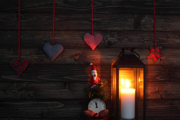 Christmas decorations and candle with toy Santa Claus and clock in dark interior.Cristmas concept. New Year concept.