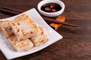 Delicious turnip cake, Chinese traditional local dish radish cake in restaurant with soy sauce and...