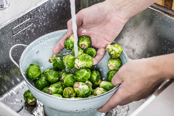 washing raw Brussels sprouts in kitchen sink
