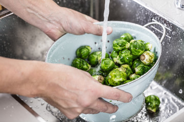 washing raw Brussels sprouts in kitchen sink
