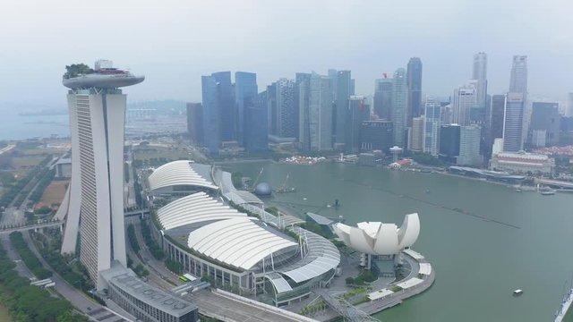 Travelling aerial shot of Marina Bay Sands with Singapore City Skyline as background during Cloudy day