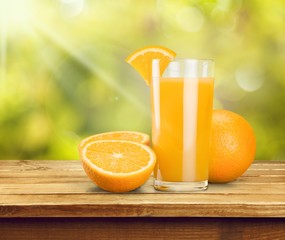 Glass of delicious orange juice on natural background