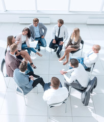 business training participants sitting in a circle and looking at the camera