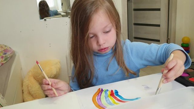 little girl blonde draws watercolors in the album