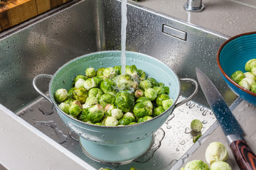washing raw Brussels sprouts in kitchen sink