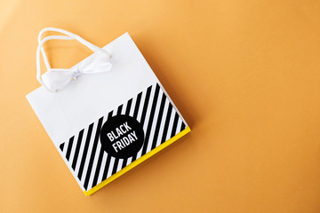 white shopping bag with black label on yellow background.Black friday concept