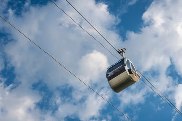 Cable car against blue sky with white clouds. Cable car connects Sparrow Hills (well known as Vorobyevy Gory park) with Sport Complex Luzhniki. Moscow, Russia.