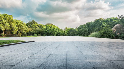 The sun shining through a tree on a green meadow, a vibrant rural landscape with blue sky before sunset