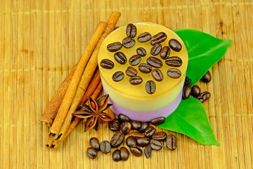 Coffee custard jelly with coffee bean placed on top decorated with green leaves, coffee bean, cinnamon sticks and star anise on bamboo mat.