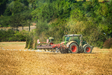 Fototapeta na wymiar tracteur et sa remorque pour labourer les champs dans un joli paysage
