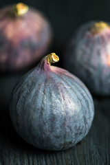 purple berry, figs close-up on a dark wooden background