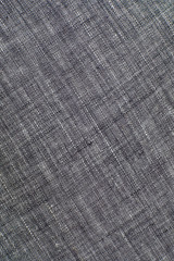 Fototapeta na wymiar The texture of gray natural linen fabric with longitudinal threads located diagonally. Not uniform dyeing of the fibers. Abstract background.
