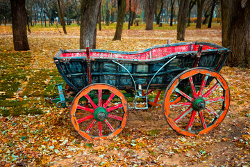 Fototapeta na wymiar Abandoned festival cart in the autumn park.