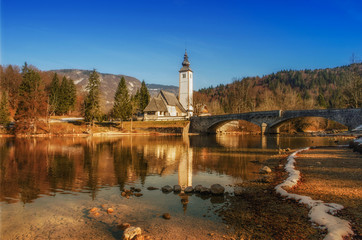 Autumn reflections on lake Bohinj, Julian Alps, the largest permanent lake in Slovenia and the...