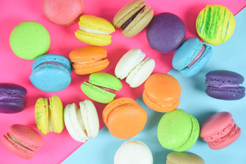 French colorful macarons on pink background 