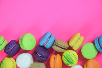 French colorful macarons on pink background 