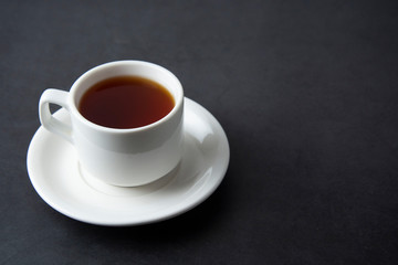 A cup of black tea isolated over dark background with copy space.