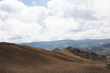 Obraz premium Landscape of colombian mountains with Andes Mountain Rage, whith crops. Blue sky with clouds. Rock hills