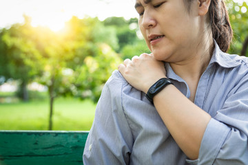 Unhappy asian woman having neck or shoulder pain,female patient suffering from pain in shoulder,joint pain,muscle ache,sore in the body,symptom excruciating,feeling tingling,health problem concept