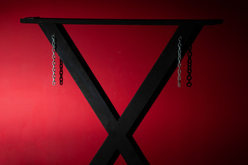  SM cross or Andreaskreuz is used in the BDSM scene on red background - obrazy, fototapety, plakaty