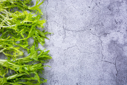 Various Green Leafy Vegetables In Row On White Background. Top View Point.