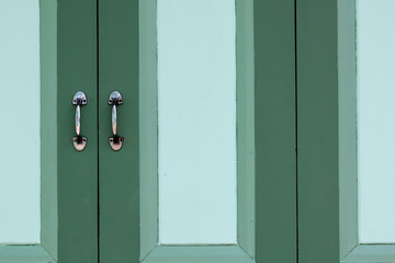 metal handle of a green classic wooden window.