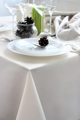 Christmas dinner by candlelight, white plates on a light background, restaurant.