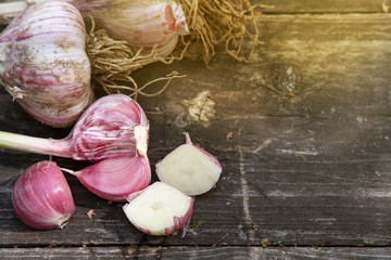 autumn harvest concept. Autumn composition with whole and sliced garlic on a dark wooden table. Copy space. Rustic natural style background. Top view