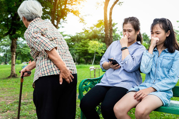 Asian daughter and granddaughter holding breath with fingers on nose,something stinks,senior mother holding her bottom,elderly woman have gas in digestive tract,farting make a bad smell while walking