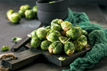Frischer roher Rosenkohl auf einem dunkelem Holztisch