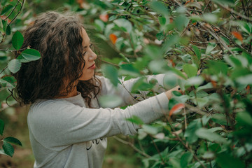 Happy young woman harvest aronia in garden on sunny day