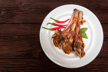 Roasted lamb ribs served on plate. Top view